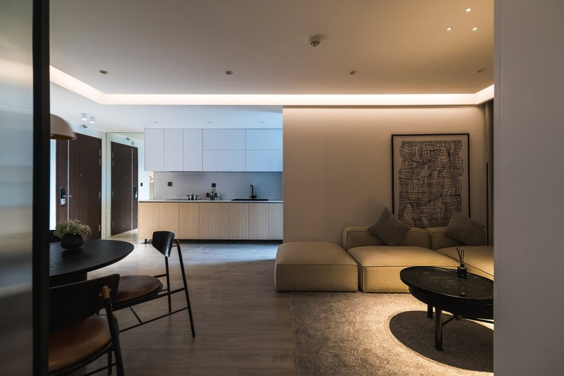 Một góc ảnh khác của không gian phòng khách và bếp ăn của căn hộ mang phong cách tối giản