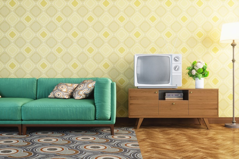 Chiếc Sofa màu xanh ngọc nổi bật kết hợp với chiếc tivi đặc trưng của những năm 90 tạo nên không gian phòng khách đậm chất Retro