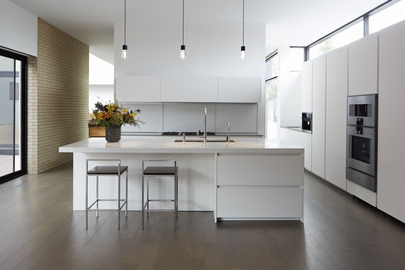 Không gian phòng bếp tối giản ưa chuộng nội thất trơn màu, bình hoa trang trí tạo điểm nhấn sinh động cho không gian