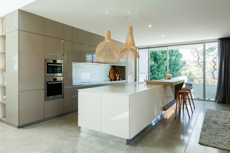 Phòng bếp tối giản bao gồm hệ tủ được trang bị đầy đủ thiết bị bếp hiện đại, kết hợp với đảo bếp mở rộng không gian lưu trữ